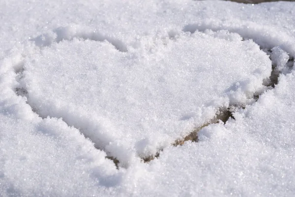 Heart outlined on snow, symbol of love, snow background