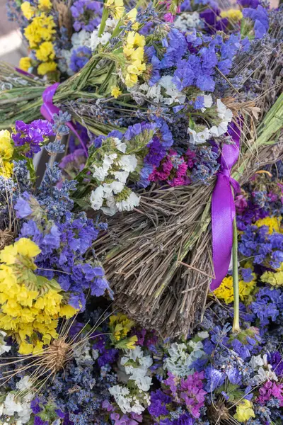 Kurumuş yabani çiçeklerin yatağı, güzel yaz bitkilerinin doğal arka planı. Dikey fotoğraf