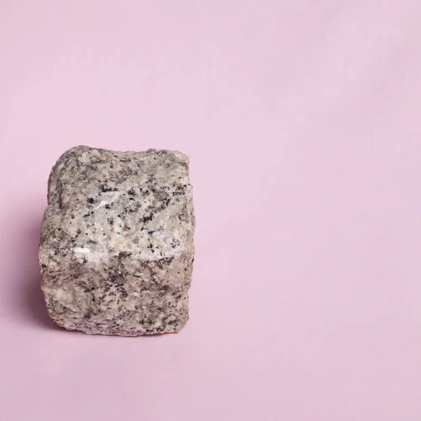 Stock image 1. Granite cube on a pink background