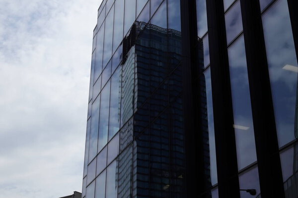 A reflection of a modern skyscraper in the glass