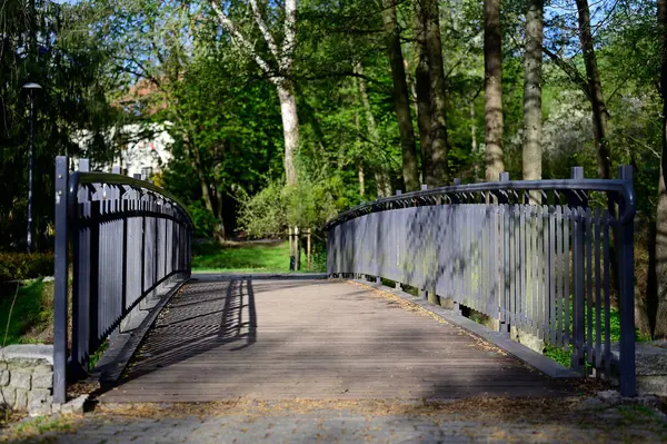 Tahta köprü ve parktaki demir parmaklıklar.