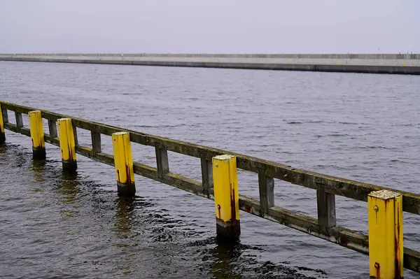 Sarı direkler ve gri dalgalar