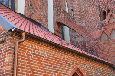 Kırmızı tuğlalı kilisenin eğimli çatısı ve duvarları