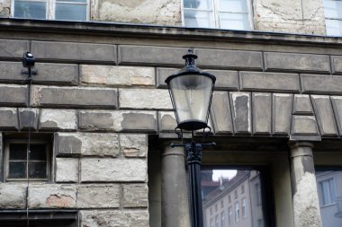 Eski bir apartmanın arka planına karşı bir sokak lambası