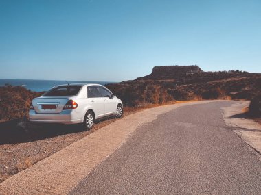 Dağ yolundaki beyaz araba. Sonbahar doğa manzarası. Seyahat, turizm, tatil, özgürlük ve aktif yaşam tarzı konsepti. Kıbrıs