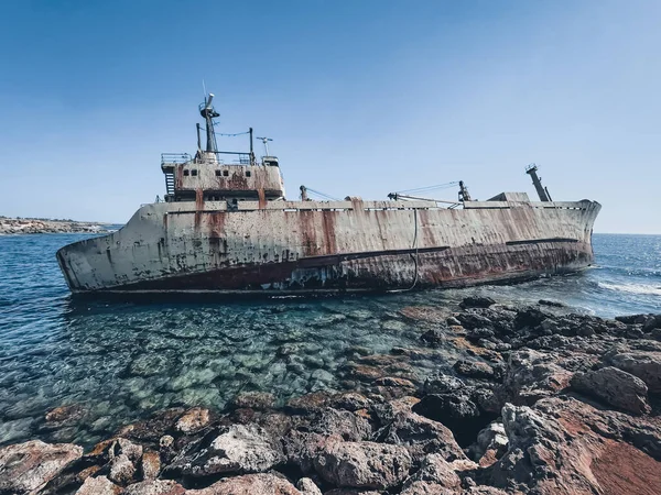 stock image Abandoned ship wreck Edro III lying on the stones seashore. The rusty shipwreck is stranded on Peyia rocks at kantarkastoi sea caves, Coral Bay, Pafos, Cyprus standing at an angle near the shore.