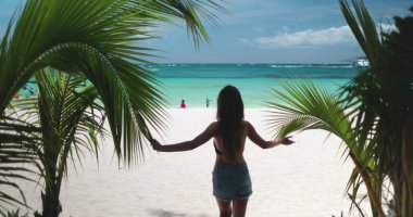 Filipinler 'deki Boracay Adaları Beyaz Sahili' nin kumlu sahilinde bir kadın güven içinde duruyor. Kristal berrak mavi sular ve yumuşak beyaz kum güzel bir zemin oluşturur..