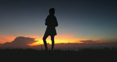 Tepenin tepesinde durmuş renkli bir gün batımını seyreden bir kadının silüeti. Görüntü Tayland 'da bir tatil köyünde çekildi. Doğal manzaranın güzelliğini gözler önüne seriyordu..