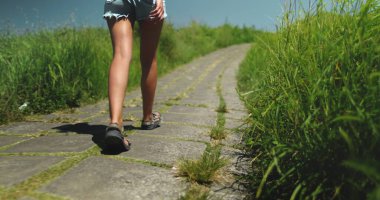 Endonezya 'nın Bali Adası' nda, Ubuds Campuhan Tepesi Yolu 'nun yanındaki kırsal yolda yürüyen bir kadın. Kadın bacakları kırsal yolda koşmaya başlıyor. Yaz tatili için açık hava gezisi,