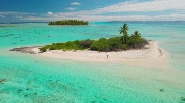 Kadın, tropik bir adada, kolları açık, turkuaz okyanus, palmiye ağaçları ve mavi gökyüzü ile çevrili bir yardım mesajının yanında, tehlikeli ve izole bir ortamda umut taşıyor.