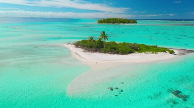 Turkuaz sular, açık mavi gökyüzünün altında palmiye ağaçlarıyla çevrili küçük bir adayı kuşatıyor. Sizi bir dron tarafından yakalanan bu nefes kesici tropikal cennete kaçmaya davet ediyor.