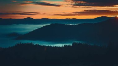 Yükselen güneş, gökyüzünü canlı renklerle boyuyor. Karpat dağlarının zirvelerine ılık bir parıltı saçıyor. Aşağıda yoğun bir sis denizi vadileri dolduruyor.