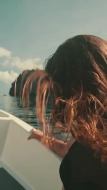 Dikey Ekran Videosu. Sürat teknesindeki kız ağır çekimde rüzgar uzun saçlar savuruyor. Genç dişiler sürat teknesinin tadını çıkarırlar. Canlı hissetmek, özgür konsept. Filipinler, El Nido Adaları 'na tatil turu