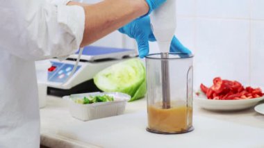 Restorandaki aşçı kadın zeytinyağı salatası sosu için ev yapımı tatlı ve ekşi sos yapıyor. Profesyonel aşçı karışımı karışımı karıştırıyor. Sağlıklı ve diyet gıda teslimatı konsepti. 4K görüntü
