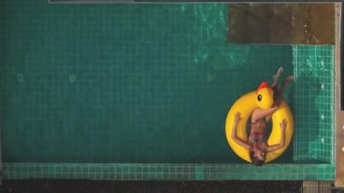 Sarı ördek şişme yüzüğünde yüzen bir kadın, özel villada yaz tatilinin tadını çıkarıyor. Kız dışarıda hayat tarzı seyahati yapıyor. Hava görüntüsü statik çekim