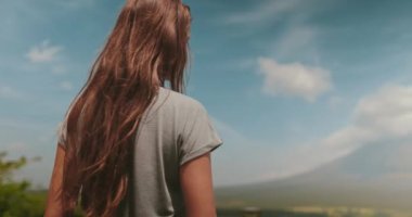 Genç kadın Filipinler 'deki mayon volkanı manzarasının tadını çıkarıyor. Volkan popüler bir turistik yerdir ve mükemmel koni şekliyle ünlüdür.