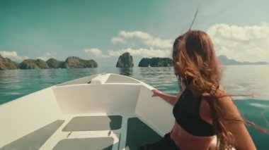 Sürat teknesindeki uzun saçlı genç kadın güzel deniz taşları manzarasının tadını çıkarıyor. Kafkasyalı güzel esmer kız rahatla, seyahat et, turizm, tatil. Filipinler, El Nido Adaları, tekne turu. Yavaş çekim