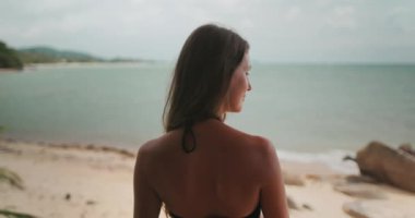 Güzel kız yaz tatilinde tatil köşkünün terasında dinleniyor. Arka planda tropik ada deniz manzarası boş kumsal sahili. Tayland egzotik adasına seyahat. Arka plan yakınlaştır