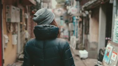 Turist kız Japon kültürünü keşfediyor Golden Gai Tokyo sokaklarında yürüyor. Kadın arka sokaklardan, barlardan, dükkanlardan hoşlanıyor. Sonbahar tatili için açık hava seyahati. Yavaş çekim 4K