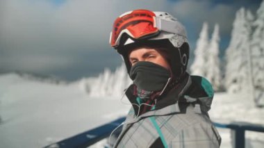 Kayak kıyafetleri kaskı takan ve Google 'da arama yapan kayak merkezinde rahatlar. Dağın tepesindeki kadın portresi. Snowboard kızı karlı dağ ormanlarının tadını çıkarıyor. Kış tatili. Yavaş çekim