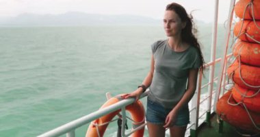 Surat Thani 'den Tayland' daki Koh Phangan Adası 'na giden bir teknenin güvertesinde duran bir kadın. Ufka bakıyor, deniz melteminin ve çarpıcı okyanus manzarasının tadını çıkarıyor..