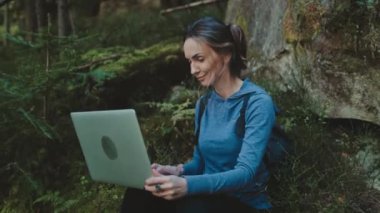 Yeşil Orman 'da dizüstü bilgisayarda yaratıcı kadın tipleri. Kadın defter üzerinde çalışıyor. Teknoloji kavramı online dijital göçebe işi modern insanlar için. Seyahat, turizm, yürüyüş, özgürlüğün tadını çıkar.