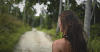 Dişi dağ yürüyüşü Pam Ağacı Ormanı patikası yakınlarda. Güzel, uzun saçlı, beyaz bir kız egzotik ada doğasını keşfediyor, rahatlıyor, yaz tatilinde açık havada seyahat ediyor. Asya. Arka plan
