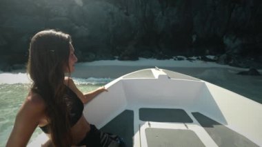 Sürat teknesinde vahşi ada kayalıkları sahiline demir atan bir kız. Uzun saçlı, beyaz tenli, bikinili bir kadın. Yat okyanusu gezisinin tadını çıkarıyor. Güvertede oturuyor, yaz tatilinde seyahat ediyor. Yavaş çekim