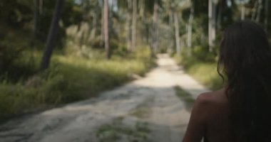 Tayland tropik ada ormanlarında keşfedin ve rahatlayın. Kadın, Hindistan cevizi palmiyeleri fidanlığı bahçesinde kırsal yolda yürüyor. Egzotik manzara. Yaz tatilinde açık hava seyahati.