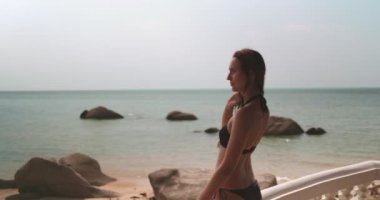 Kadınlar okyanus manzaralı villa manzarasını severler. Tatilde yaşam tarzı ve tatil kavramı. Siyah bikinili beyaz kadın. Bayan yaz tatilinde kristal mavi suda dinleniyor. Yavaş çekim