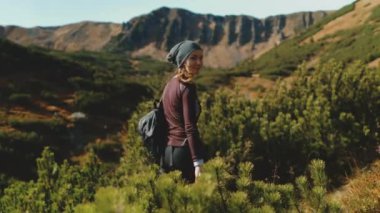 Karpatlar 'da turist yolunda yürüyen genç bir kadın, arka planda Shpytsi dağları. Vahşi doğa sahnesi. Yaz tatilinde açık hava seyahati. Seyahat, yürüyüş, aktif hayat. Yavaş çekim 4K
