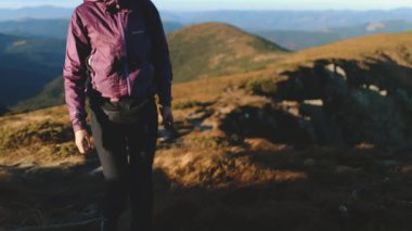 Karpatlar 'ın dağ manzarasından hoşlanan iki yürüyüşçü, yaya yolunda teçhizatla yürüyor. Doğayı kucaklamak, yeni manzaralar keşfetmek ve açık havada aktif olmak.