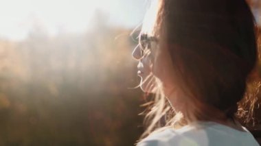 Genç bir kadın elinde bir çimen tutarak Karpat Dağları 'ndaki doğanın huzur ve sükunetinin tadını çıkarıyor.