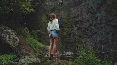 Kadınlar yemyeşil tropikal bir ormanda saçlarına merakla dokunan gizli bir şelaleye hayrandır. Fransız Polinezyası 'ndaki yaz maceraları için mükemmel.