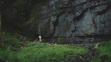 Genç bir kadınla yemyeşil ormanı keşfetmek, şelale sesleri. Tropikal ormanda macera ve sükunet. Yalnız gezgin vahşi doğada özgürlük arıyor.