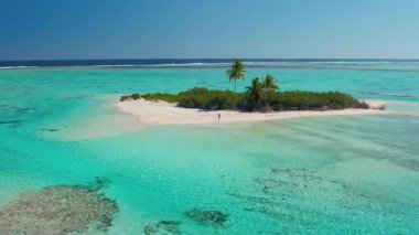 Seyahat konsepti arka planı - turkuaz su mercan resifi denizindeki küçük tropikal ada. Mükemmel kumsal, palmiye ağacı, kristal su. Kuma yazılmış bir seyahat, el sallayan bir kadın. Hava aracı uçuşu