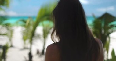 Boracay 'da beyaz bir sahilde gevşeyen bir kadın, Filipinler, tropik bir cennette huzurlu bir tatilin tadını çıkarıyor.