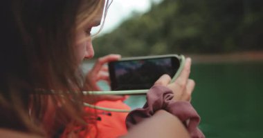 Turist kadın, Tayland 'ın vahşi doğasının fotoğrafını çekerken tropik adalarda tekne turunun tadını çıkarıyor. Güzel Kafkas dişileri açık havada seyahat tatilinin tadını çıkarırlar. Portreyi kapat, yavaş çekim.