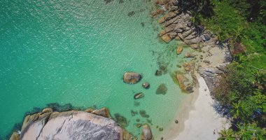 Bu nefes kesen kıyı manzarası, bereketli yeşilliklerle çevrili kumlu bir plaja çarpan kristal berraklığında turkuaz suları vurguluyor. Kayalık oluşumlar eşsiz bir kıyı şeridi oluşturur.