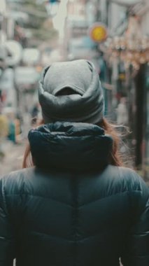 Tokyo 'da küçük şehir caddesinde yürüyen bir kadın turist. Beyaz kız eski restoranları, barları, içki barları olan arka sokaklardan hoşlanıyor. Golden Gai Caddesi, Japon. Arka plan yavaş çekim. Seyahat, turizm