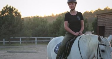 Çayırda at süren bir atlı, güneş batarken sakin bir akşam yolculuğunun tadını çıkarıyor, altın ışıkla dolu sakin ve resimsel bir manzara yaratıyor.