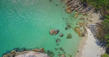 Bu nefes kesen kıyı manzarası, bereketli yeşilliklerle çevrili kumlu bir plaja çarpan kristal berraklığında turkuaz suları vurguluyor. Kayalık oluşumlar eşsiz bir kıyı şeridi oluşturur.