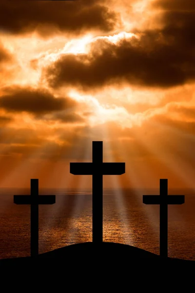 Silhouette of Jesus Christ crucifixion on cross on Good Friday Easter over heaven sunset sunrise -Three Crosses On Hill vertical