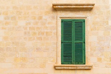 Kapalı yeşil ahşap pencereli taş duvar panjurlu..