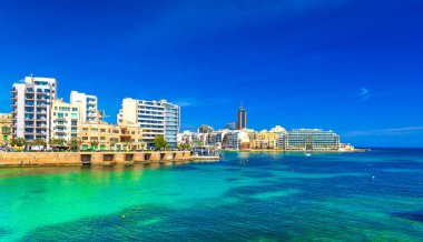Güneşli bir günde, açık mavi gökyüzü ve turkuaz suyla St. Julians Körfezi manzarası, Malta