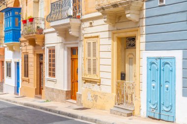 Geleneksel mimari tarzında eski binaları olan tipik bir Malta sokağı manzarası, Malta.