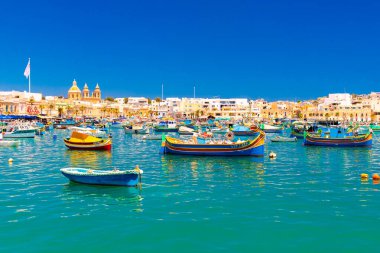 Marsaxlokk - 4 Mayıs 2025, Malta: Malta 'nın güneyindeki küçük bir geleneksel balıkçı köyünde renkli balıkçı tekneleri bulunuyor.