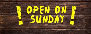 Pazar günü İngilizce Açık 'ta yazılmış resim floresan sarısı ve koyu kahverengi ahşap arka planda büyük ünlem işaretleri var.