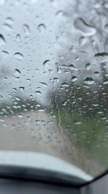 Camdan arabanın üzerine yağmur damlaları düşer. Sonbahar arabayla seyahat eder.