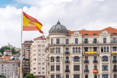 Santander Limanı 'nda İspanyol bayrağı. Arka planda Santander 'in şehir merkezinin güzel mimarisi. San Fermin kutlamaları için bayraklarla süslenmiş bina ve balkonlar.. 